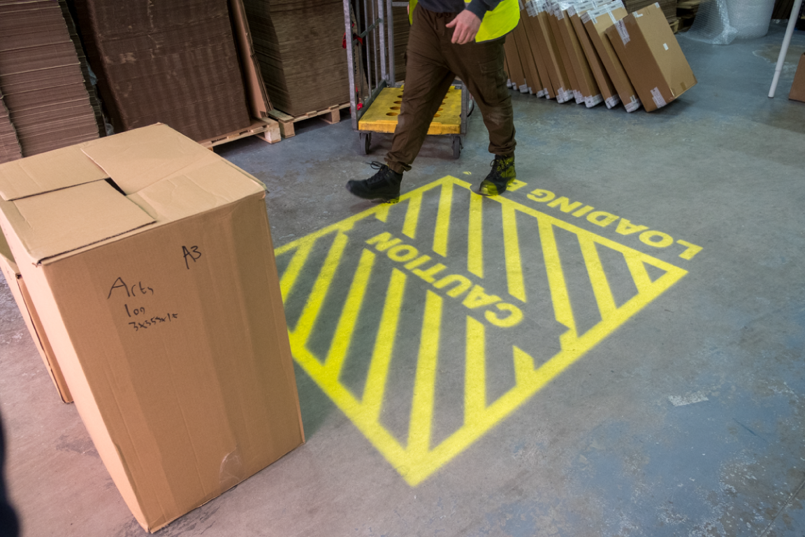 Projected safety signage is critical for warehouse automation.