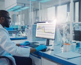 Modern Medical Research Laboratory: Scientist working on Computer Showing Green Chroma Key Screen. Scientific Lab, Medicine Development Facility with Advanced Equipment, Biotechnology.