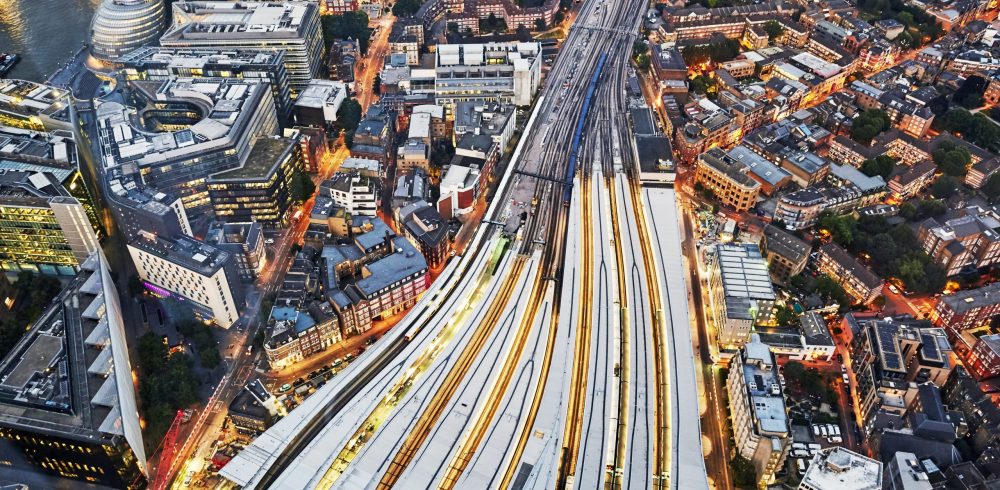 Aerial,View,Of,Train,Tracks,Entering,London,Bridge,Illuminated,At