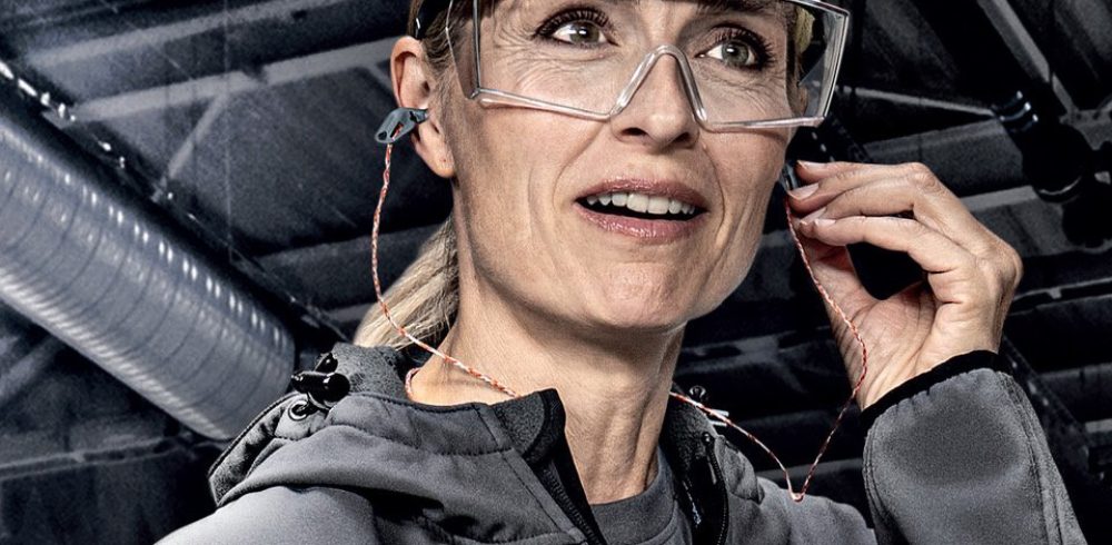 HSE noise campaign: a worker wearing uvex safety glasses fits a hearing protection earplug