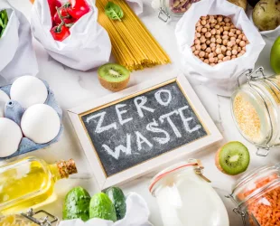 Zero waste shopping and sustanable lifestyle concept, various farm organic vegetables, grains, pasta, eggs and fruits in reusable packaging supermarket bags. copy space top view, white concrete table (Zero waste shopping and sustanable lifestyle conce